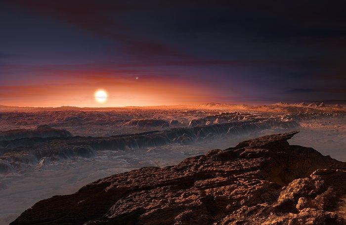 Cette représentation d’artiste montre une vue de la surface de la planète Proxima b en orbite autour de la naine rouge Proxima du Centaure, l’étoile la plus proche du Système Solaire. Le système d’étoiles double Alpha Centauri AB figure dans l’angle supérieur droit de l’image. Proxima b est dotée d’une masse légèrement supérieure à celle de la Terre et décrit une orbite autour de Proxima Centauri, au sein même de la zone d’habitabilité de cette étoile, de sorte que sa température de surface est compatible avec la présence d’eau liquide. Crédit: ESO/M. Kornmesser